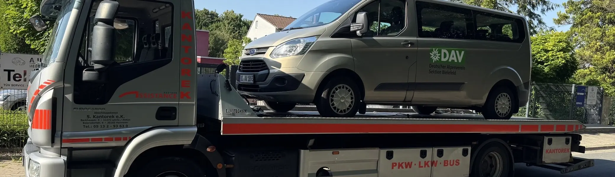 „Der Vereinsbus der DAV Sektion Bielefeld wird auf einem Abschleppwagen transportiert. Die Aufnahme entstand an einer Straße bei sonnigem Wetter und dokumentiert eine ungeplante Unterbrechung der Anreise.“ | © Gunnar Helms
