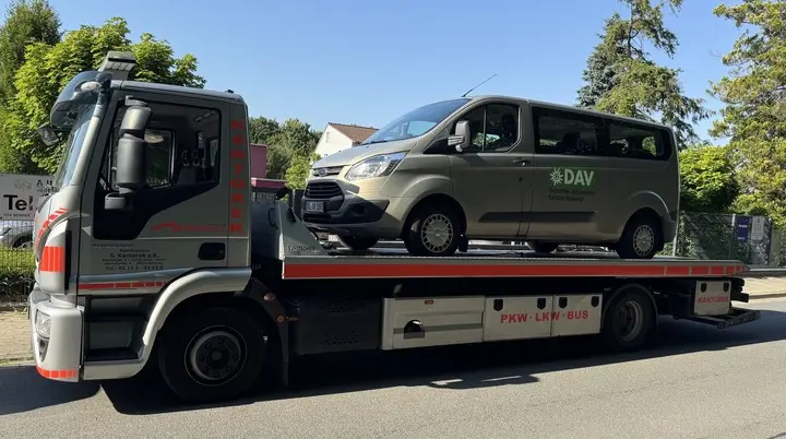 „Der Vereinsbus der DAV Sektion Bielefeld wird auf einem Abschleppwagen transportiert. Die Aufnahme entstand an einer Straße bei sonnigem Wetter und dokumentiert eine ungeplante Unterbrechung der Anreise.“ | © Gunnar Helms