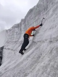 Person mit Steigeisen klettert an einer steilen Eiswand und nutzt zwei Eisgeräte zur Fortbewegung auf dem Gletscher. | © P.J.Müller