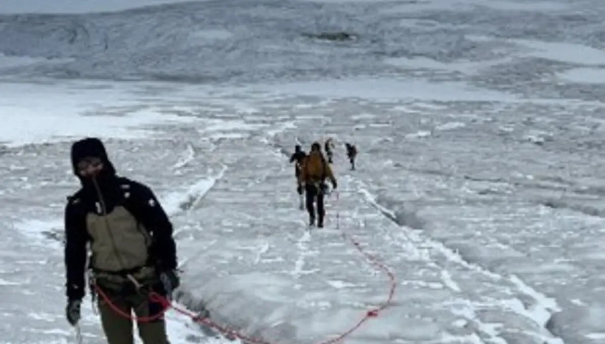 Angeseilte Gruppe bewegt sich über einen Gletscher mit sichtbaren Gletscherspalten. Im Vordergrund führt eine Person die Seilschaft durch die hochalpine Eislandschaft. | © P.J.Müller