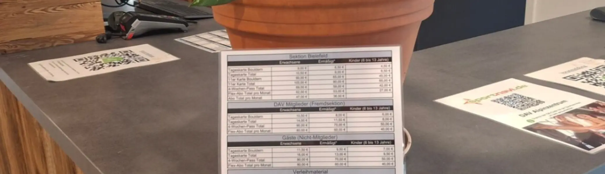 Hier sieht man die Theke des alpin zentrums mit einer kleinen Tariftafel | © DAV Bielefeld