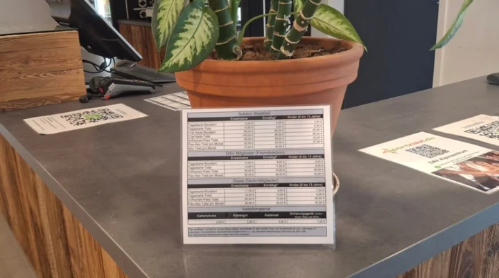 Hier sieht man die Theke des alpin zentrums mit einer kleinen Tariftafel | © DAV Bielefeld