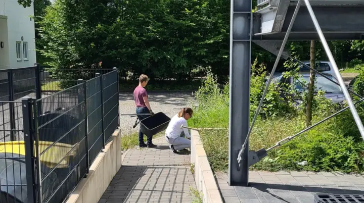 Menschen welche den äußeren Grünstreifen am alpin zentrum zurückschneiden | © DAV Bielefeld