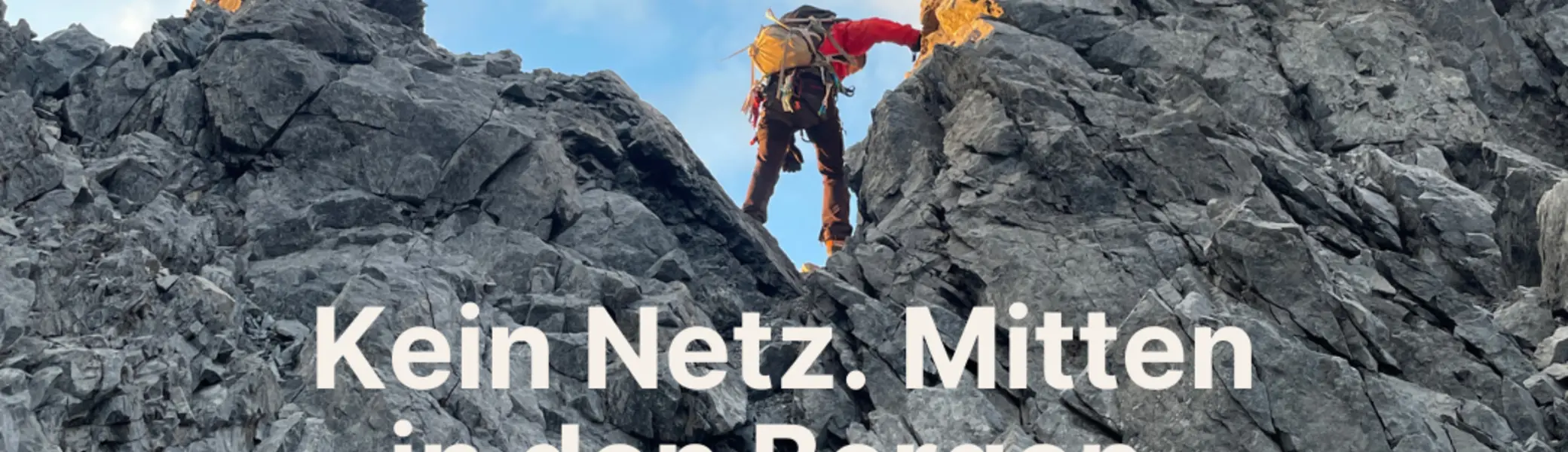 Ein Bergsteiger mit roter Jacke und Rucksack klettert über graue Felsen in einer steilen Berglandschaft. Der Himmel ist teils bewölkt, die Sonne beleuchtet die Felswand. Im oberen rechten Bereich steht das Logo „DAV Bielefeld“. In der Mitte des Bildes ist weißer Text zu lesen: „Kein Netz. Mitten in den Bergen. Und es wird ernst.“ Unten befindet sich ein grüner Balken mit der Aufschrift „Garmin inReach Mini 2 — jetzt im Materialverleih“. | © Joachim Brenne