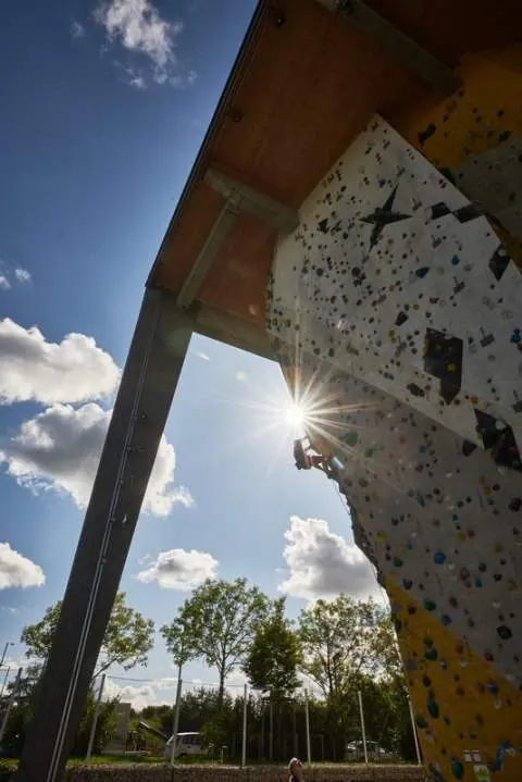 Ein Mann klettert an einer künstlichen Kletterwand | © DAV